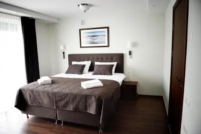 a bedroom with a bed with two towels on it at Motel Panorama in Šiauliai