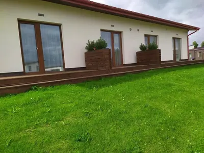 a house with a green lawn in front of it at Motel Panorama in Šiauliai