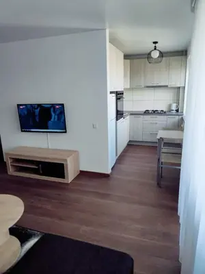 a kitchen with white cabinets and a tv on the wall at Trumpalaikė nuoma centre in Šiauliai