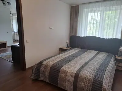 a bedroom with a bed and a large window at Trumpalaikė nuoma centre in Šiauliai