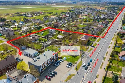 an aerial view of a city with a red arrow pointing to an air kenn at Air Kaunas in Karmėlava