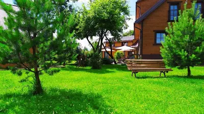 a bench sitting in the grass in front of a house at 