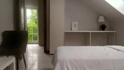 a bedroom with a bed and a desk and a window at 