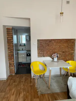 a living room with a table and yellow chairs at Gediminas apartment in Kaunas