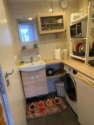a small kitchen with a sink and a washing machine at Gediminas apartment in Kaunas