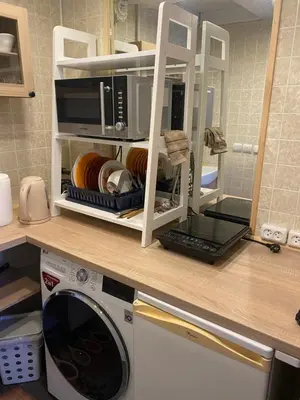 a kitchen counter with a microwave and a washing machine at Gediminas apartment in Kaunas
