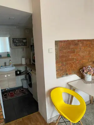 a yellow chair in a small kitchen with a table at Gediminas apartment in Kaunas