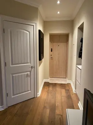 an empty hallway with a white door and wooden floors at Studio flat in Kedainiai in Kėdainiai