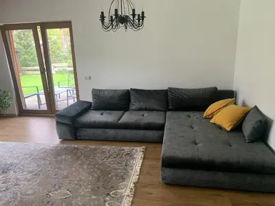 a living room with a gray couch and a chandelier at Kulautuva Rest Home Large Space in Kulautuva