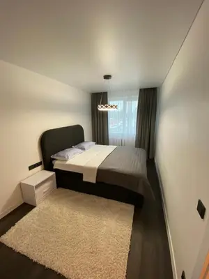 a small bedroom with a bed and a rug at Parko 443 in Panevėžys
