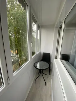 a small table in a room with two windows at Parko 443 in Panevėžys