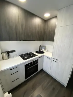 a kitchen with white cabinets and a stove top oven at Parko 443 in Panevėžys