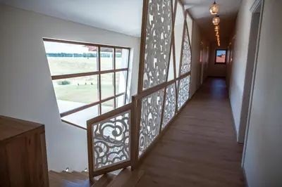 a hallway with wrought iron railings and a window at Sodyba Pelėdų medus in Vainekoniai