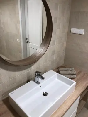 a bathroom with a white sink and a mirror at Sodyba Pelėdų medus in Vainekoniai