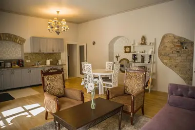a living room with a table and chairs and a kitchen at Gaono apartment Free Parking in Vilnius