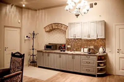a kitchen with white cabinets and a sink and a chandelier at Gaono apartment Free Parking in Vilnius