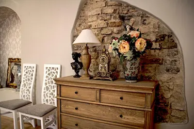 a room with a dresser with a lamp and flowers on it at Gaono apartment Free Parking in Vilnius