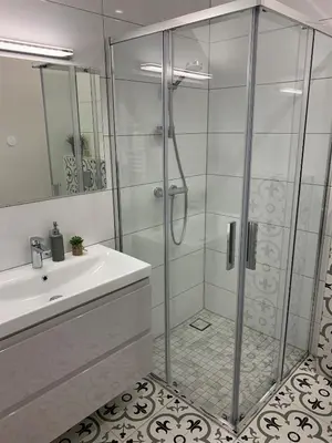 a bathroom with a glass shower and a sink at COZY Nest apartment in Kaunas in Kaunas