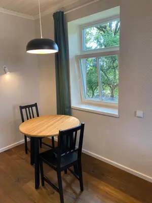 a dining room table with two chairs and a window at 