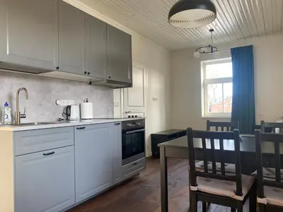 a kitchen with white cabinets and a table with chairs at 