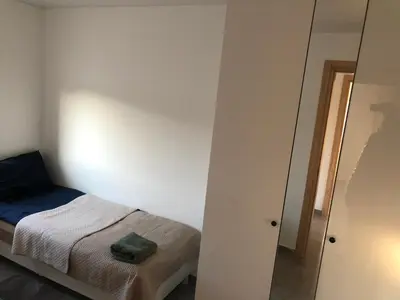 a small bedroom with a bed and a mirror at Villa Ievyne 2 in Paežeriai