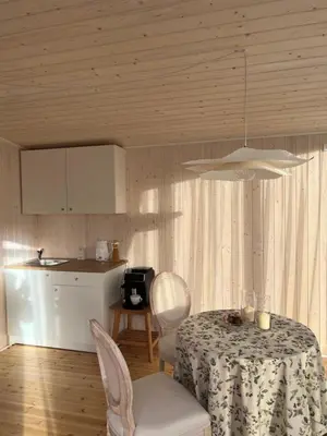 a dining room with a table and a kitchen at Walnut House in Kulautuva