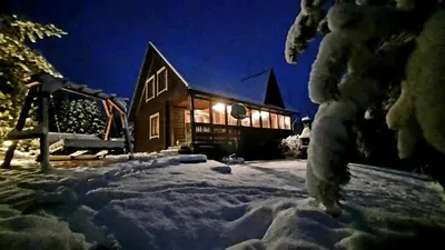 a house is covered in snow at night at Sodyba Vilagio in Alanta