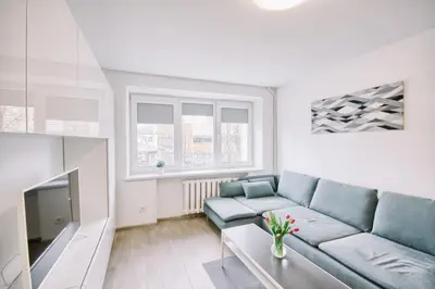 a living room with a blue couch and a tv at DaGys apartments in Druskininkai