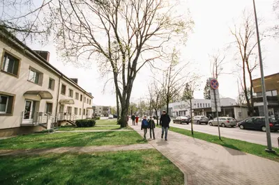 a group of people walking down a sidewalk at DaGys apartments in Druskininkai