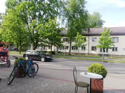 a bike parked on a sidewalk next to a street at DaGys apartments in Druskininkai
