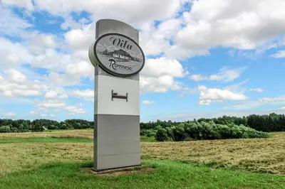 a sign in the middle of a field at Vila Romnesa in Ignalina