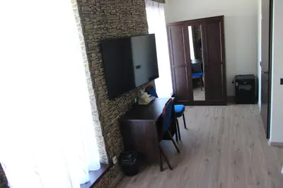 a living room with a television on a brick wall at Vila Romnesa in Ignalina