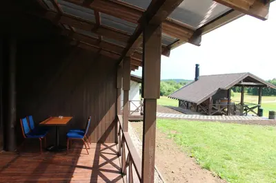 a porch of a house with a table and chairs at Vila Romnesa in Ignalina