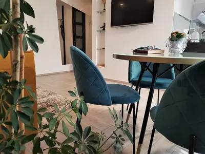 a dining room with blue chairs and a table at Apartment For You in Šiauliai