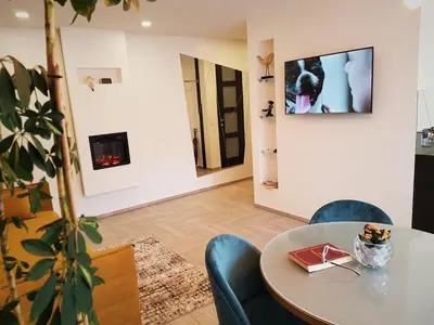 a dining room with a table and chairs and a fireplace at Apartment For You in Šiauliai