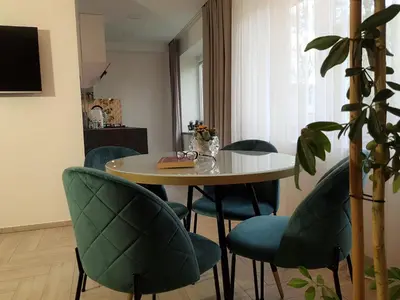 a dining room with a table and blue chairs at Apartment For You in Šiauliai