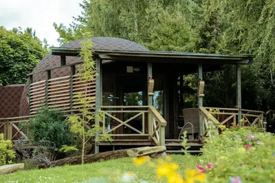 a gazebo in the middle of a garden at Akmenos Villas & Bungalow in Bražuolė