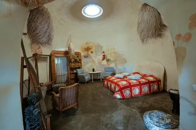 a bedroom with a bed and a table and chairs at Akmenos Villas & Bungalow in Bražuolė