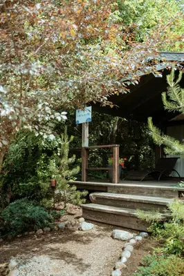 a set of stairs in a garden with a sign at Akmenos Villas & Bungalow in Bražuolė