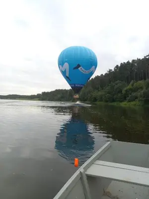 a blue hot air balloon floating in the water at Solo studio in Birštonas