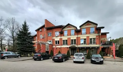 a large building with cars parked in a parking lot at Solo studio in Birštonas