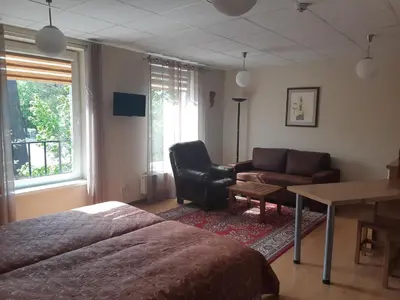 a bedroom with a bed and a chair and a desk at Solo studio in Birštonas