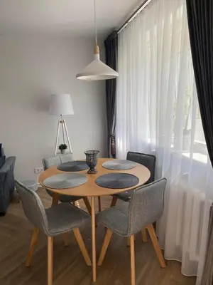 a dining room table with four chairs and aendant light at DanGinta in Druskininkai
