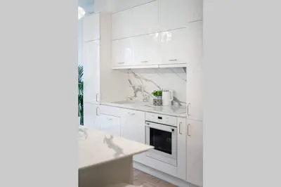 a white kitchen with white cabinets and a sink at Jogailos Residence peaceful Old Town luxury 3 bdr, 2 bthr, FREE GARAGE, top-speed WIFI in Vilnius