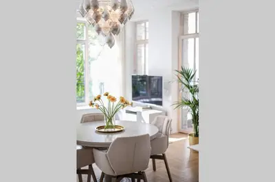 a dining room with a table and chairs and a chandelier at Jogailos Residence peaceful Old Town luxury 3 bdr, 2 bthr, FREE GARAGE, top-speed WIFI in Vilnius