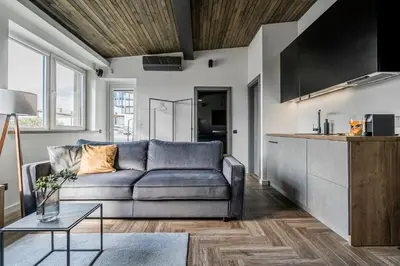 a living room with a couch and a table at CUTE Apartment Šiauliai FREE Parking in Šiauliai
