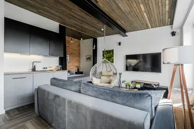 a living room with a couch and a kitchen at CUTE Apartment Šiauliai FREE Parking in Šiauliai