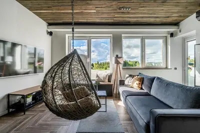 a living room with a couch and a hanging hammock at CUTE Apartment Šiauliai FREE Parking in Šiauliai