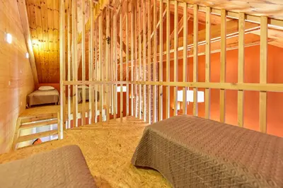 a bedroom with a bed in a wooden room at Spacious Loft in the Nature in Molėtai