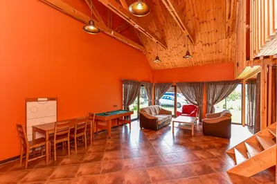 a dining room with orange walls and a table and chairs at Spacious Loft in the Nature in Molėtai
